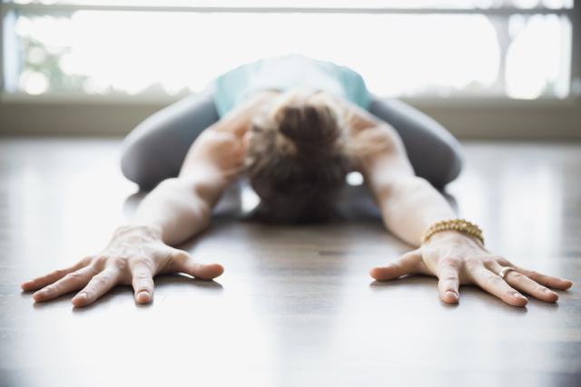 Woman practicing yoga in childs pose stretching arms